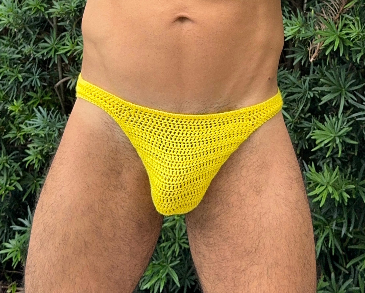 Front view of model wearing crochet men’s swim briefs made from this downloadable pattern.
