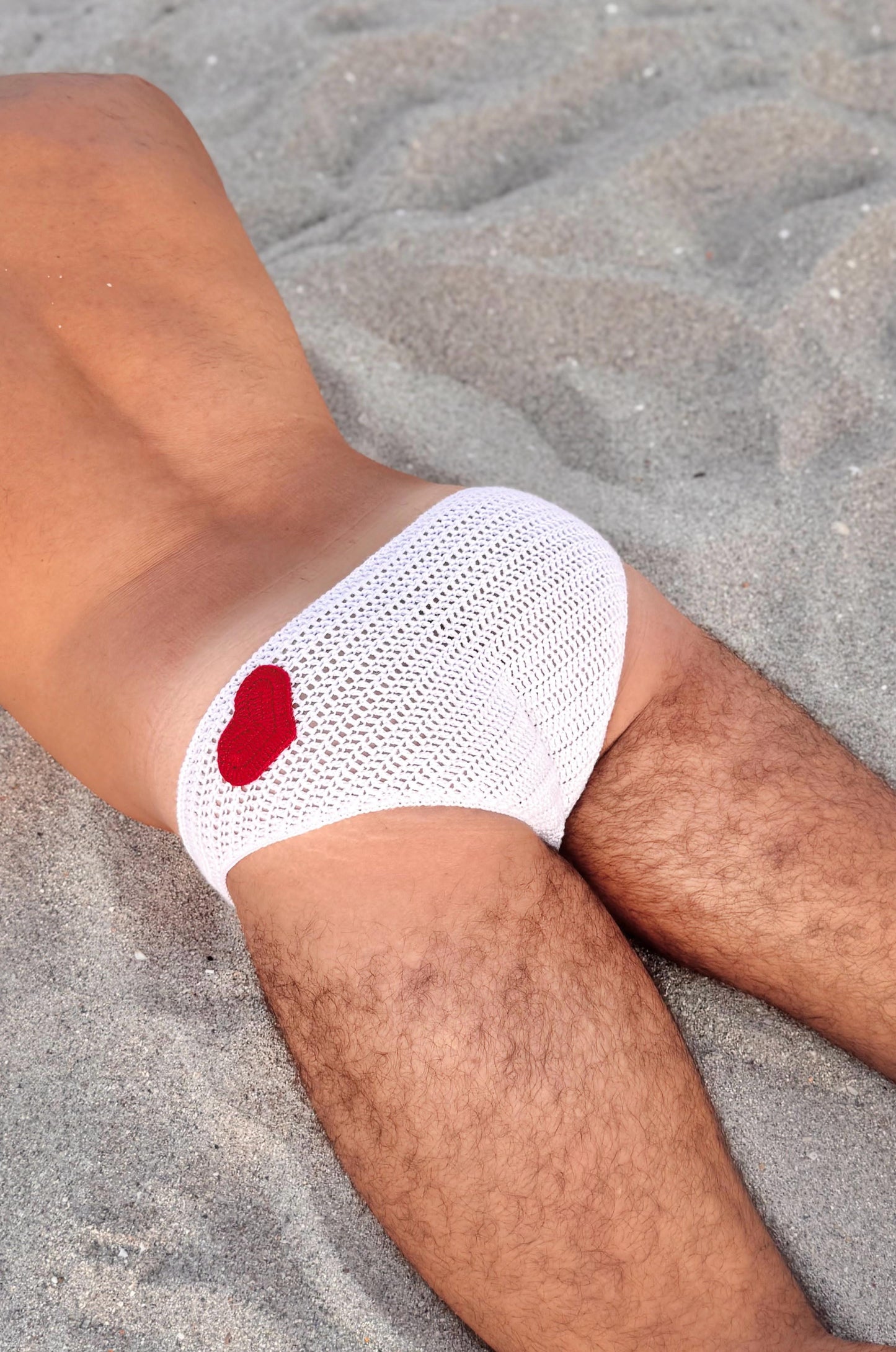 Crochet men's heart swim briefs, showcasing beachwear aesthetic for men.
