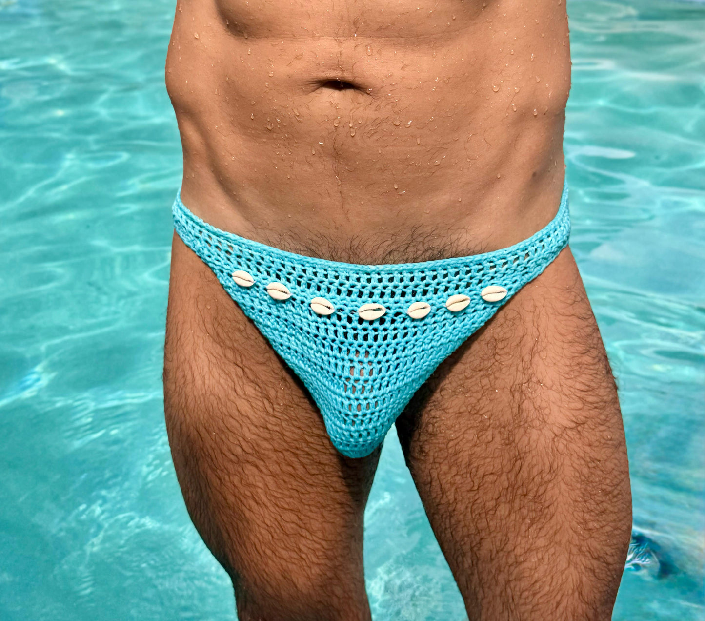 Macro close-up of crochet stitches and seashell design on handmade men’s swim briefs.