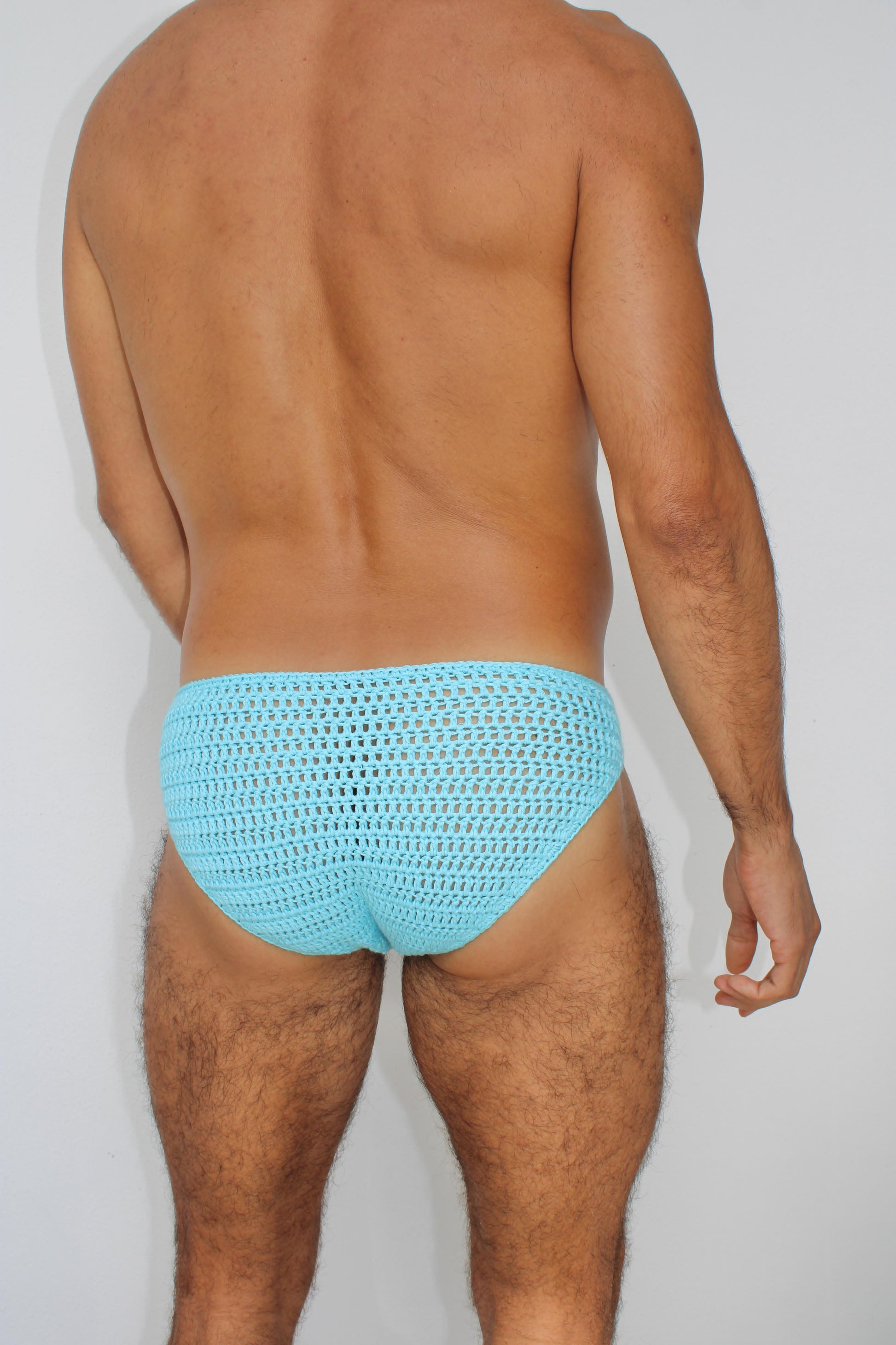 Back angled view of men’s crochet seashells briefs, showcasing fit and airy structure.