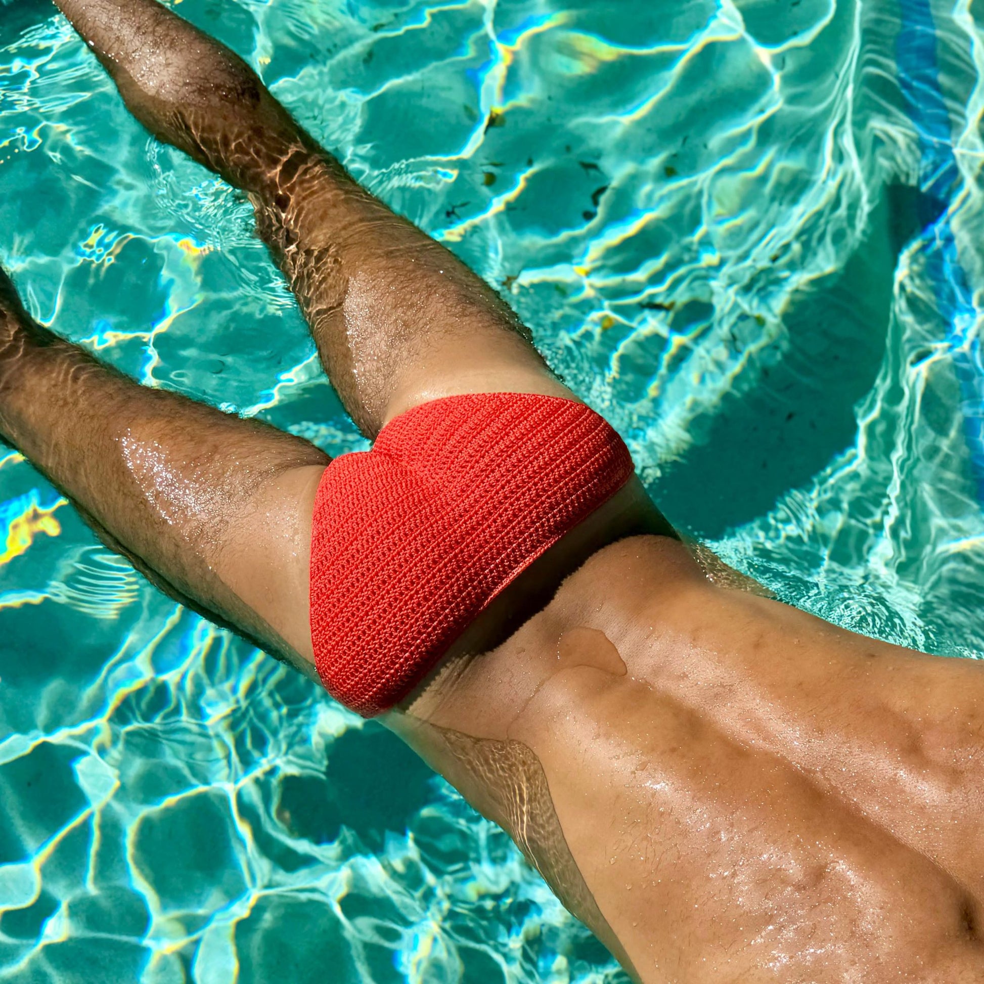 Classic crochet mens swim briefs in red back view in swimming pool handmade beach swimwear
