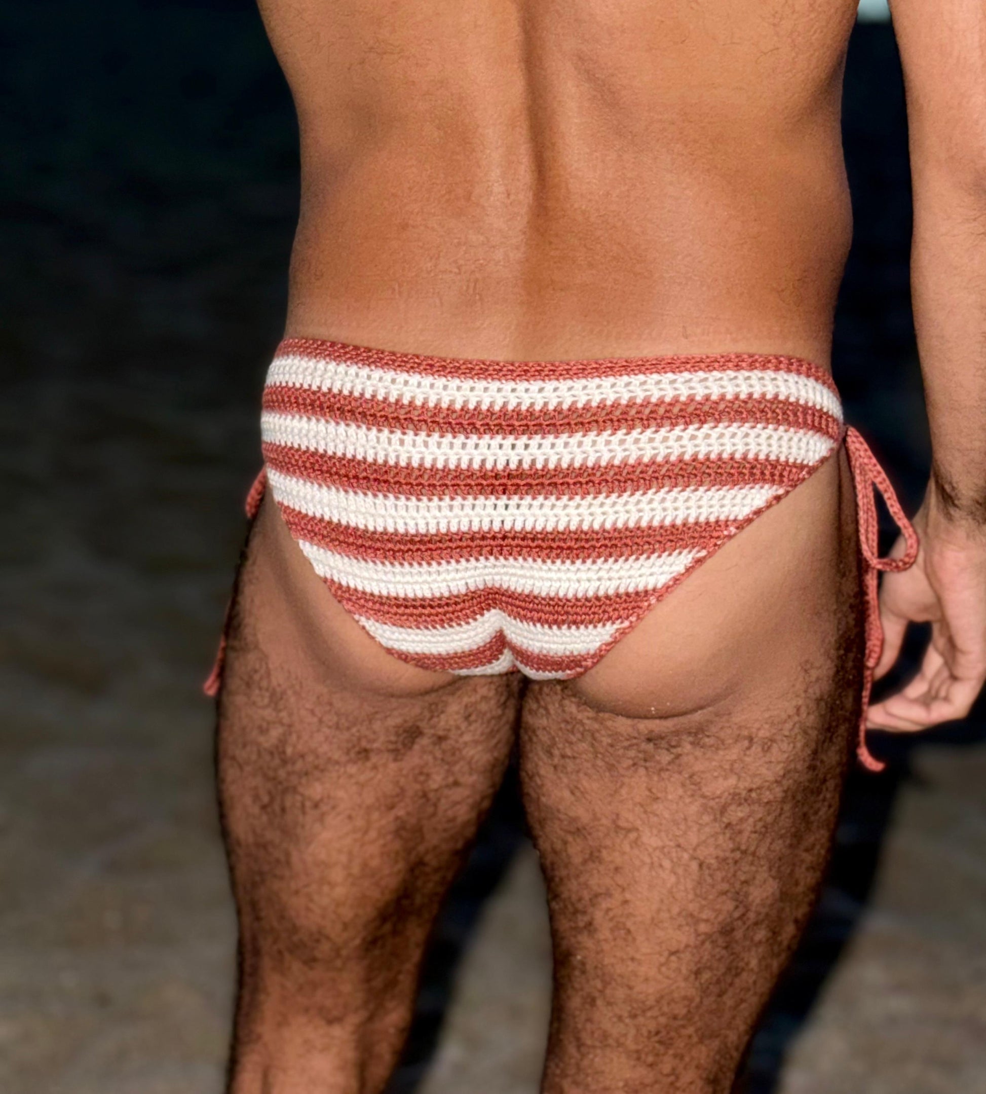 Back view of handmade crochet men's striped tie side swim briefs made from soft cotton yarn.